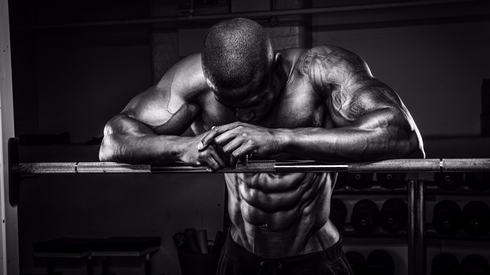 men-standing-with-hands-on-barbell-showing-his-muscles